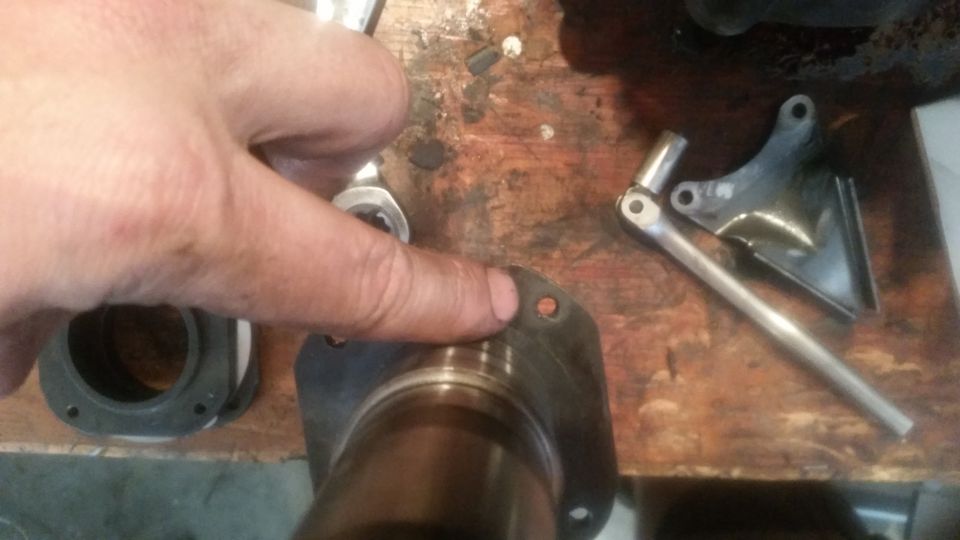 Close-up of a gasket on a bearing, with a hand and tools in the background.
