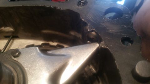 1985 Ford Bronco - A close-up view shows a metal component with a jagged edge, possibly part of an engine or transmission, with visible sealant around the ope…