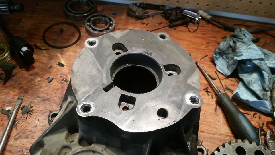Close-up of a metal vehicle part on a workbench with tools.