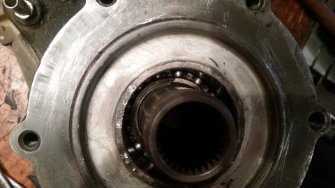 1985 Ford Bronco - A close-up view of a damaged bearing assembly within a metal housing. The bearing appears to have broken balls and is surrounded by a greas…