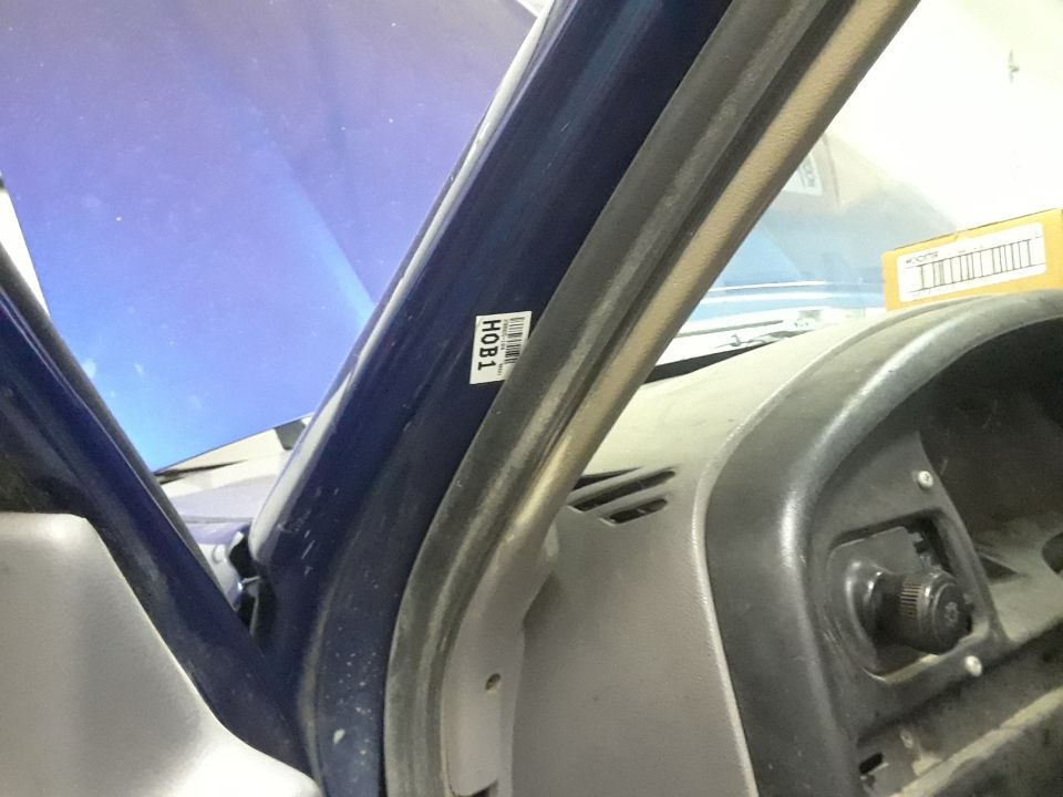 Close-up of a sticker labeled HOB1 on the interior pillar of a blue vehicle.