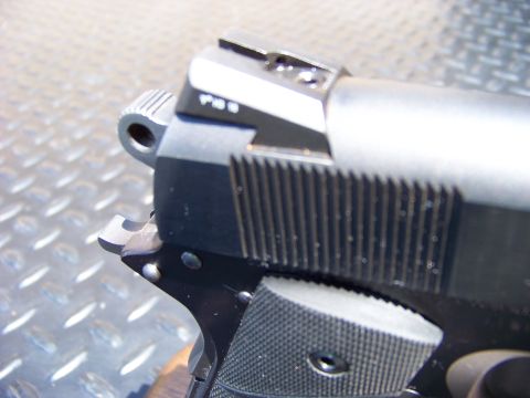 1995 Mercury Grand Marquis - The image shows a close-up view of a firearm, specifically the rear portion of the slide and frame, with a textured grip visible. The firea…