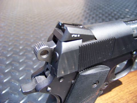 1995 Mercury Grand Marquis - Close-up view of the rear sight and hammer of a black handgun.