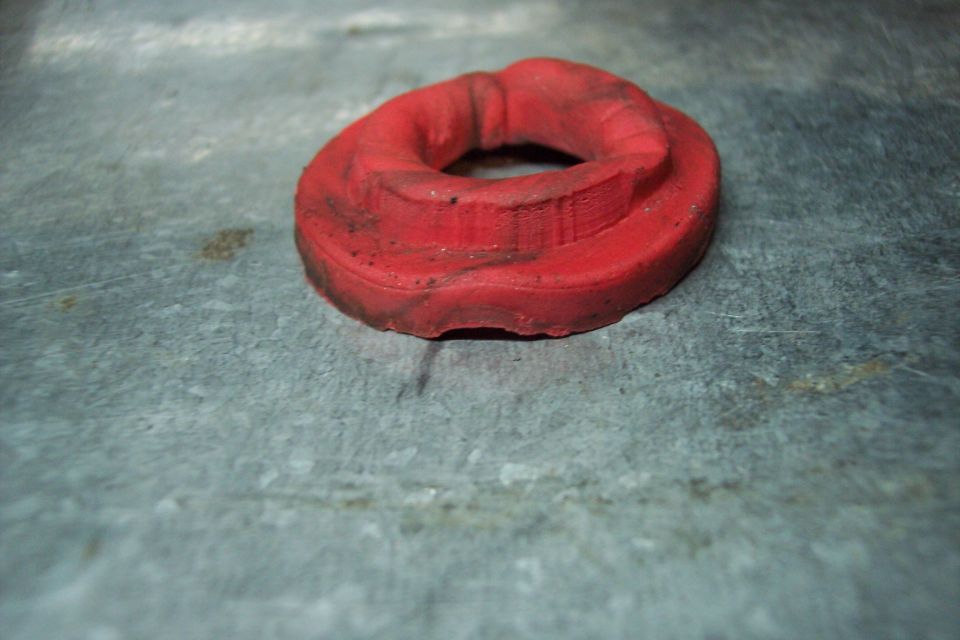Red rubber bushing on a metal surface