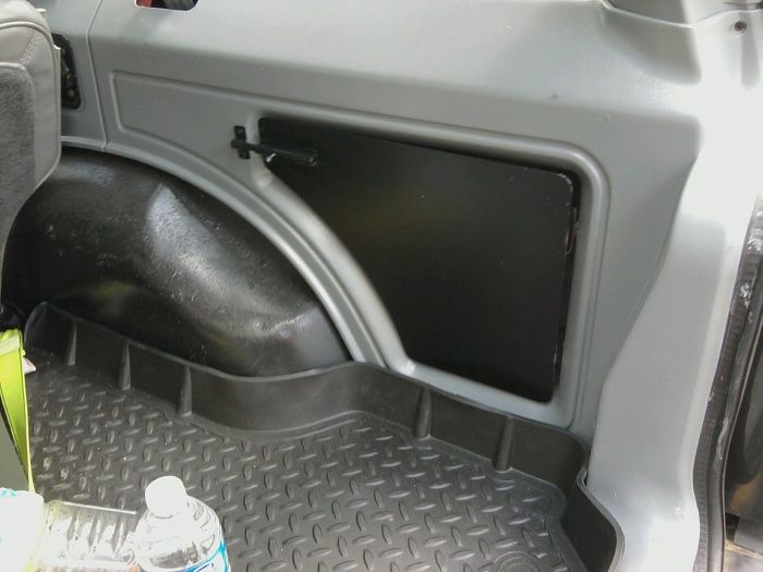 Interior cargo area with rubber floor mat and wheel well. Supermotors.net logo visible