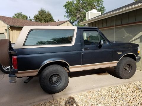 1994 Ford Bronco - This 1994 Ford Bronco is shown from the side, its dark blue paint and tan removable top.