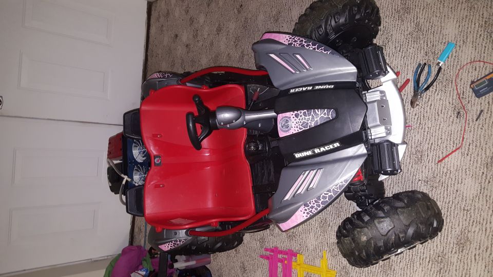 Toy dune buggy with red seat and steering wheel, "DUNE RACER" text on body