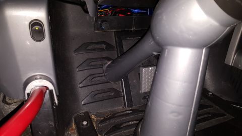 2007 Subaru Impreza - The interior of a vehicle shows a red lever, pedals, and exposed wiring in the footwell area.