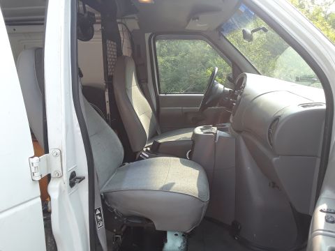 1999 Ford E250 - The interior of a 1999 Ford E250 van, the driver and passenger seats and dashboard.