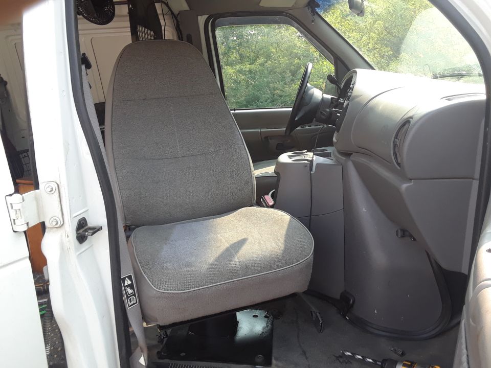 1999 Ford E250 interior showing driver's seat, dashboard, and center console