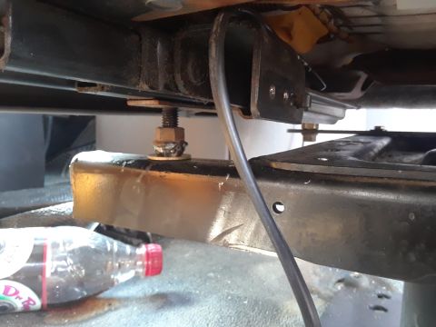 1999 Ford E250 - Close-up of vehicle interior seat mounting hardware and a discarded plastic bottle.
