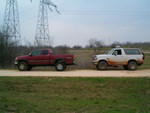 1996 Ford Bronco - 1996 Ford Bronco and red Toyota Tundra parked on a dirt road under power lines.