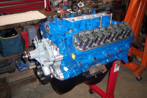 1995 Ford Bronco - A bright blue engine assembly is mounted on a red engine stand, ready for installation or rebuilding.