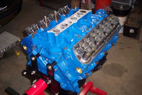 1995 Ford Bronco - A freshly painted blue V8 engine sits on an engine stand, ready for reassembly.