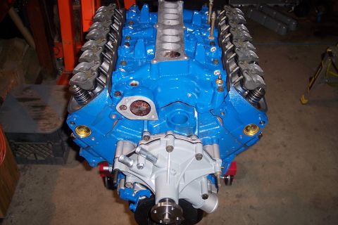 1995 Ford Bronco - A blue V8 engine is shown on an engine stand, with a silver water pump attached.