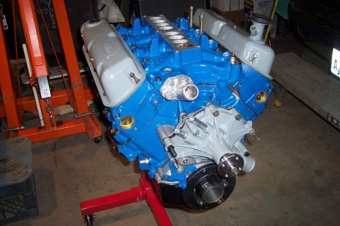 1995 Ford Bronco - A freshly painted engine sits on a stand, ready for reassembly.