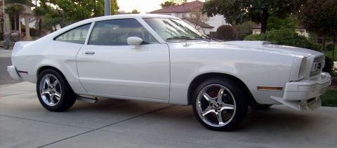 1978 Ford Mustang II - A white coupe with a distinctive body style and aftermarket wheels is parked on a paved surface.