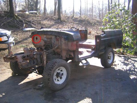1978 Ford Bronco - This stripped-down Ford Bronco body sits on a concrete surface, surrounded by trees and other vehicles in the background.