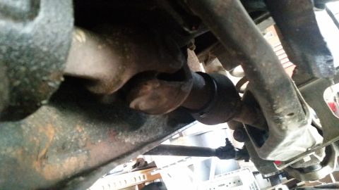 1985 Ford Bronco - This is a close-up, low-angle shot of the underside of a vehicle's drivetrain, focusing on a universal joint and surrounding suspension com…