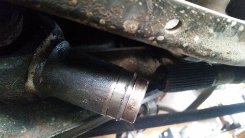 1985 Ford Bronco - A close-up view of a greasy, splined shaft extending from a dark metal component, possibly part of a vehicle's drivetrain. The shaft shows…