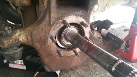 1985 Ford Bronco - A close-up view of a vehicle's front wheel hub assembly, showing a bearing and part of the axle shaft. The assembly appears to be undergoin…