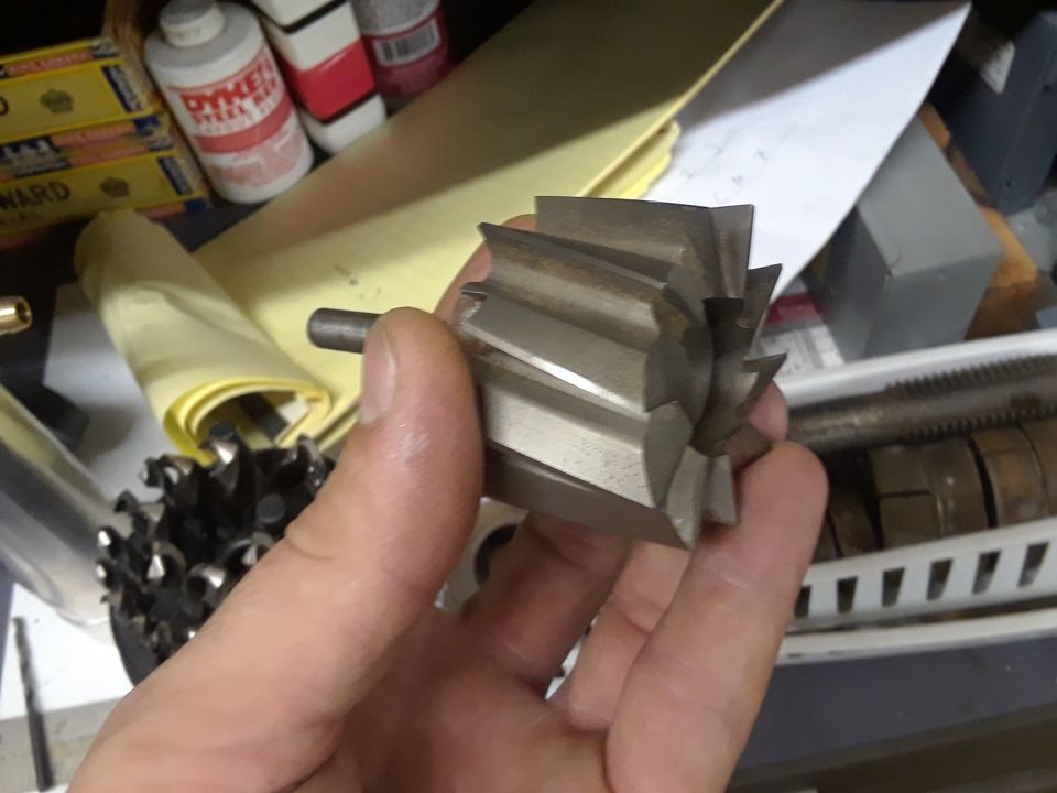Close-up of a metal cutting tool with sharp blades held in a hand.