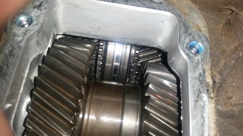 1985 Ford Bronco - Close-up view of the internal gears of a transmission or differential. The metal casing has two visible bolts with blue thread locker, and…