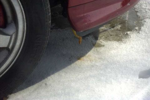 1997 Ford Taurus - A close-up view of a vehicle's side in snowy conditions, with a yellow object protruding from beneath the door.
