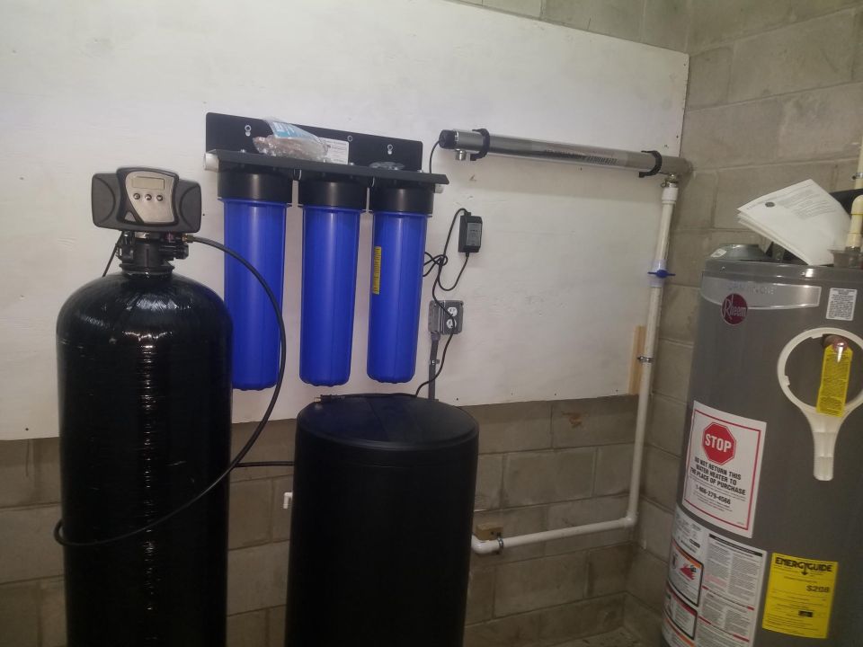 Photo of a water softener, filtration system, and water heater in a basement