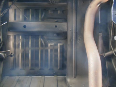1984 Ford Bronco - The underside of a vehicle, likely a truck or SUV, is shown with a section of the exhaust pipe visible on the right. The chassis and frame…