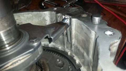 1985 Ford Bronco - A close-up view shows a metal component, possibly part of a transmission or engine, with visible welding and modifications. A gear-like com…