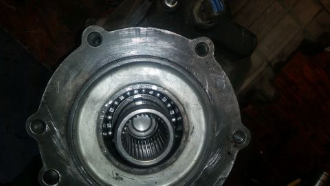 1985 Ford Bronco - A close-up view of a vehicle's wheel hub assembly, showing a bearing with multiple ball bearings and a splined shaft. The metal housing has…