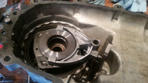 1985 Ford Bronco - This is a close-up, overhead view of the internal components of an automatic transmission housing. A large gear assembly with splines is vi…