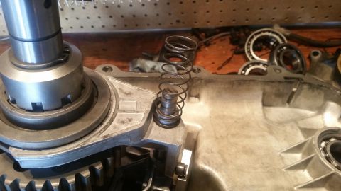 1985 Ford Bronco - A close-up view of internal transmission components, including a metal housing, gears, a spring-loaded plunger, and ball bearings. The scen…