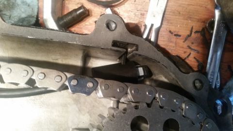 1985 Ford Bronco - A close-up view of a timing chain and gear mechanism within an engine, likely from a 1985 Ford Bronco. Tools and a wooden surface are visib…