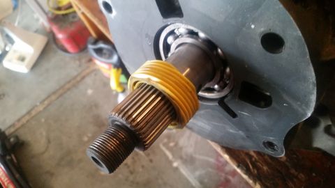 1985 Ford Bronco - A close-up view shows a splined shaft with a yellow plastic ring around it, inserted into a bearing assembly. The assembly appears to be pa…