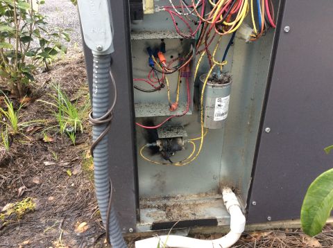 1992 Ford Bronco - This image shows the internal wiring and components of an outdoor HVAC unit. There is visible damage and charring around some of the electr…