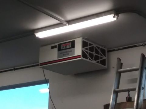 1995 Ford Bronco - A white JET air filtration system is mounted on a ceiling, illuminated by fluorescent lights. A ladder is visible to the right of the filtr…