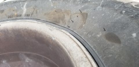 1995 Ford Bronco - A close-up view of the sidewall of a tire on a 1995 Ford Bronco, showing several small nails or staples embedded in the tread and some disc…
