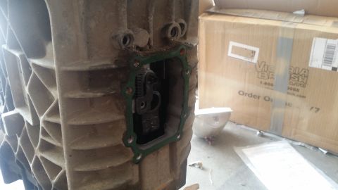 1985 Ford Bronco - A close-up view of the internal mechanism of a transmission housing, with a green gasket visible around an opening. A cardboard box with te…