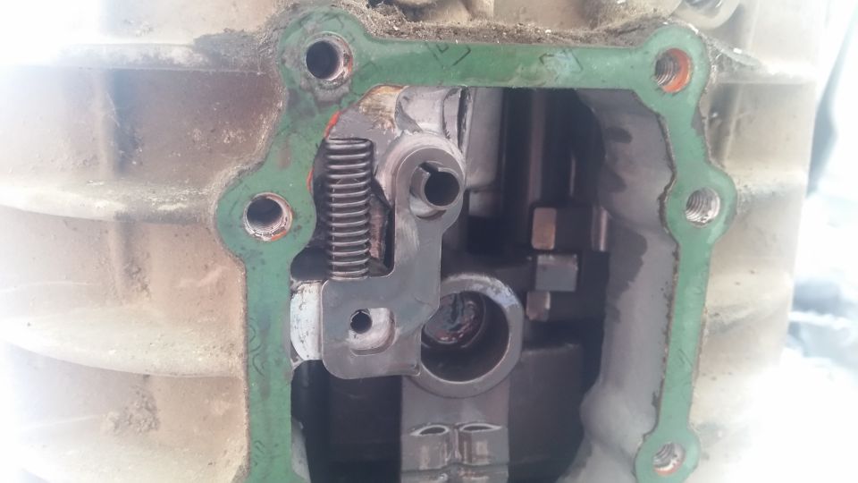 Internal view of a transmission showing a shift fork, spring, and gasket.