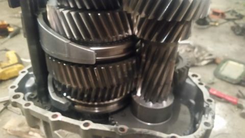 1985 Ford Bronco - Close-up of a transmission's internal gears and housing. The gears are helical and appear to be made of metal, with a silver synchronizer r…