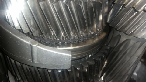 1985 Ford Bronco - A close-up view of several metal gears, likely from a transmission or differential, showing their teeth and interlocking mechanisms. The ge…