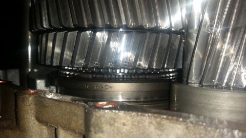 1985 Ford Bronco - A close-up view shows the internal gears of a transmission. Visible text on a ring component reads "3.73 REAR" with an arrow pointing down.