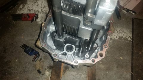 1985 Ford Bronco - A close-up view shows the internal components of a manual transmission, including gears and shift forks, within its silver casing. Tools, i…