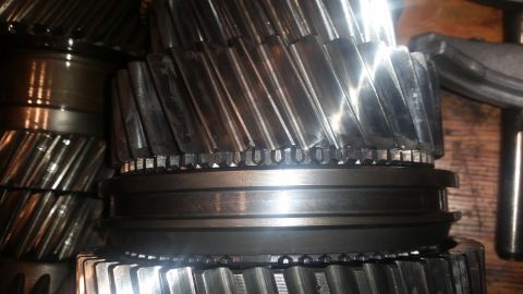 1985 Ford Bronco - A close-up view shows several large, metallic gears with helical teeth. The gears appear to be part of a transmission or similar heavy mach…