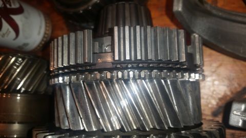 1985 Ford Bronco - A close-up view of several metal gears, likely from a transmission or transfer case. The gears have helical teeth and appear to be made of…