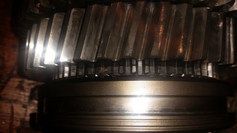 1985 Ford Bronco - A close-up, low-angle shot shows the teeth of two meshing gears, likely from a transmission or differential. The gears are metallic and app…