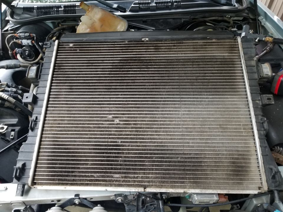Radiator and coolant reservoir removed from a vehicle's engine bay
