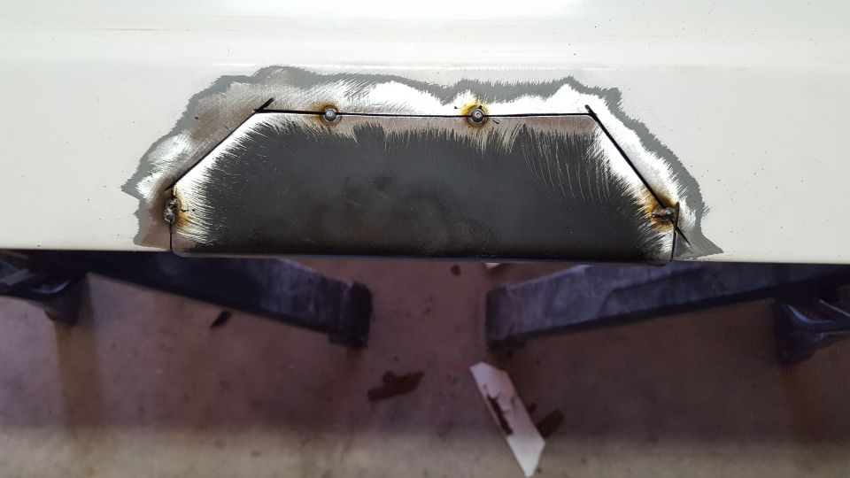 The metal underneath is prepped (no pic) and a new piece of sheetmetal cut.  Tacked it into place with the MIG.  If you're going to do this, leave a gap about the thickness of the MIG wire.  This will help with penetration.  In the next step you'll see why this is important.